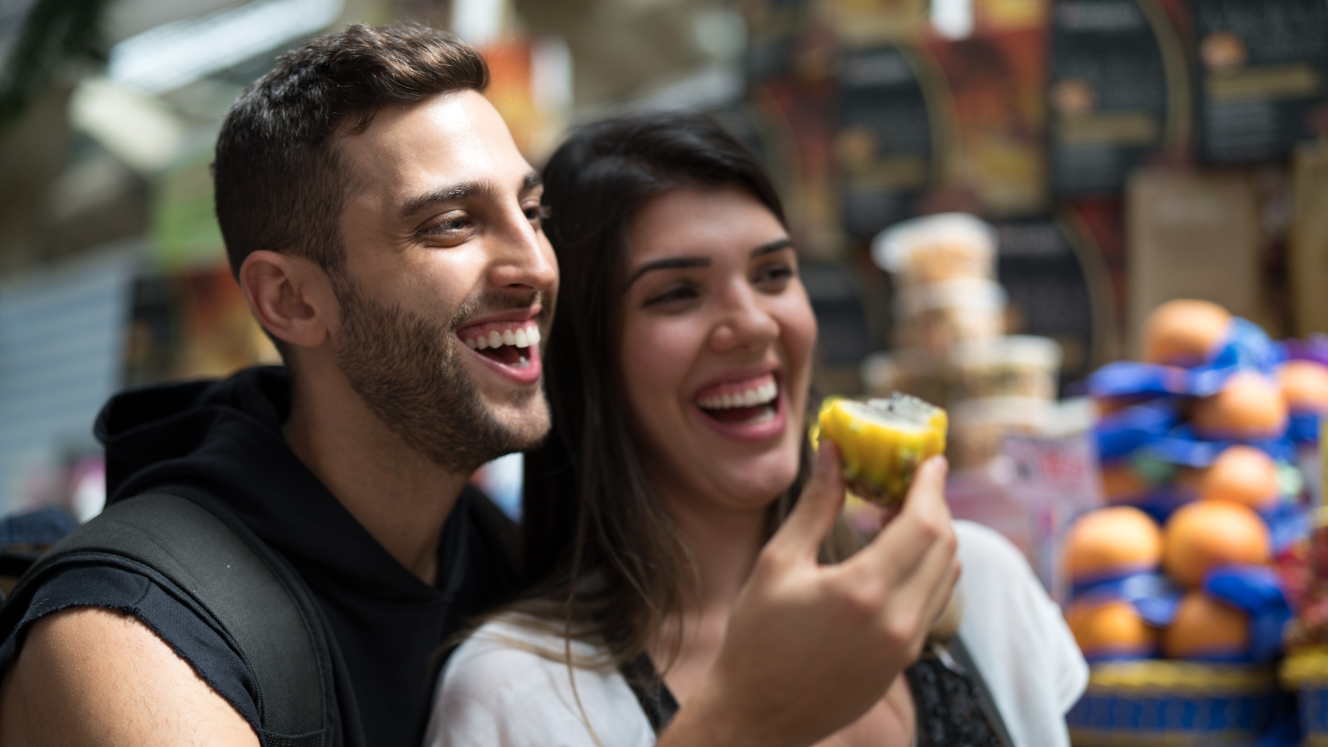 Two Brazilian people laughing in a market as the header for a blog post about Why Testimonials are Important for highlighting great experiences